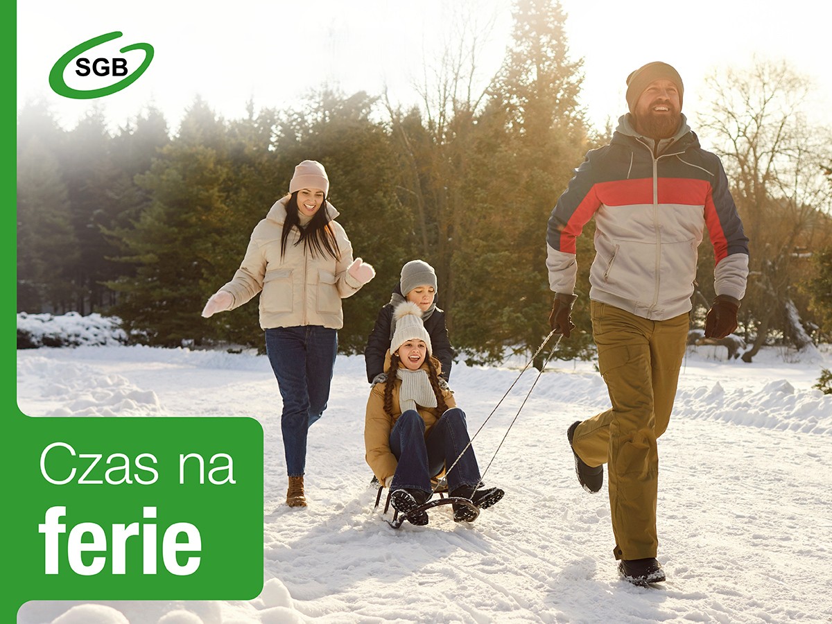 dwoje dzieci zjeżdża na sankach, kobieta i mężczyzna idą obok, w tle śnieg